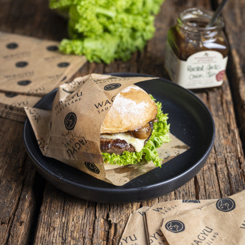 Tüte für den Wagyu-Sauerland Burger auf einem Teller, GARLIC ONION JAM