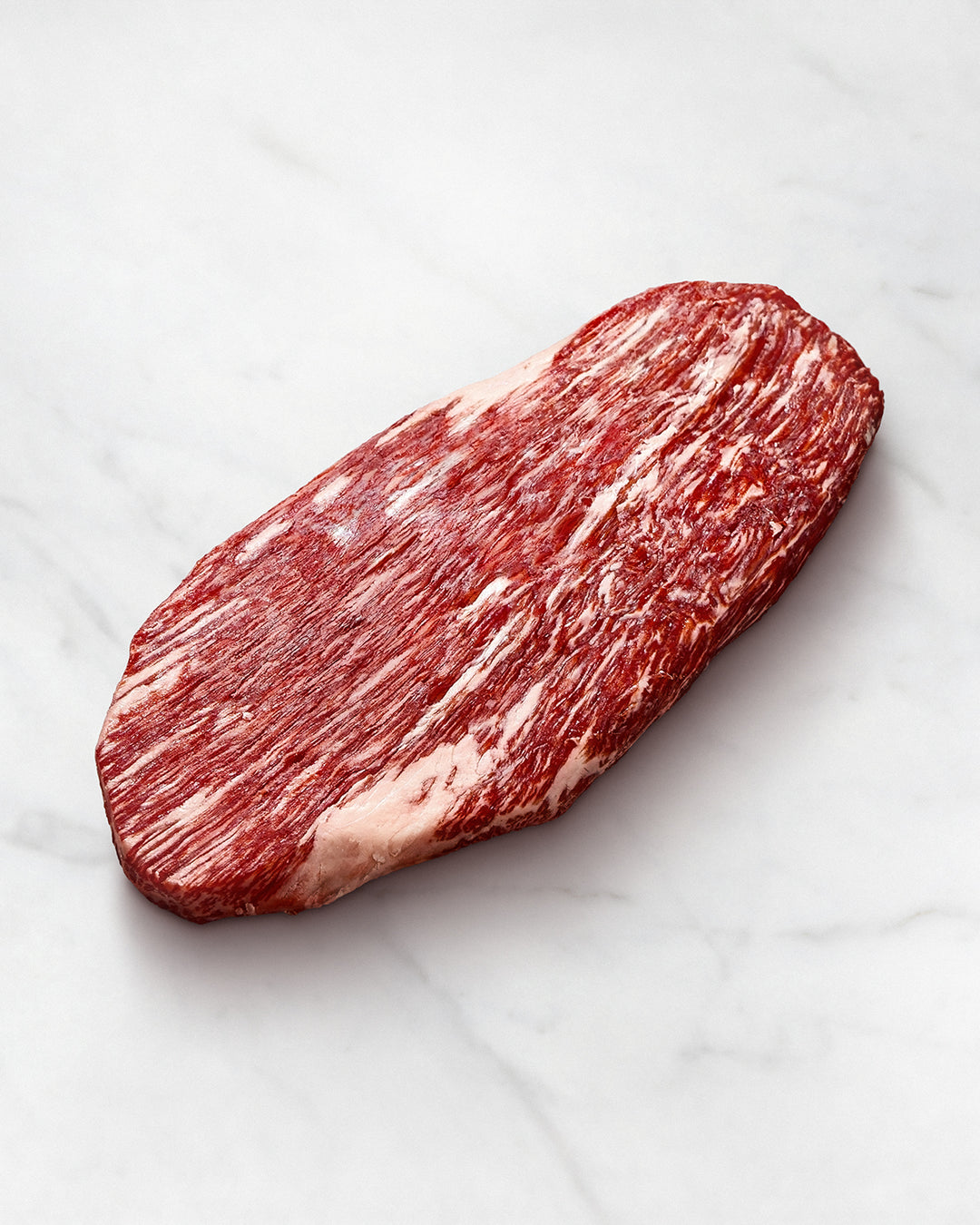 Wagyu-Flank vom Rind auf weißem Hintergrund, Kobe Beef roh, lange Fasern, starke marmorierung, Lappensteak, ohne marinade, auch als falsches Filet, Wadenmuskelsteak und Kavalierspieß bekannt, Preis