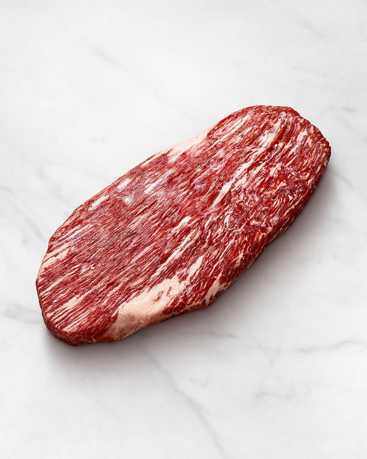 Wagyu-Flank vom Rind auf weißem Hintergrund, Kobe Beef roh, lange Fasern, starke marmorierung, Lappensteak, ohne marinade, auch als falsches Filet, Wadenmuskelsteak und Kavalierspieß bekannt, Preis