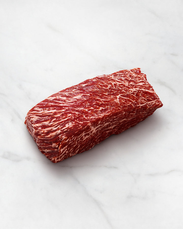 Bavette Steak schneiden und vorbereiten, Wagyufleisch auf einem weißen Teller, stark marmoriert, Wagyu Flap Steak