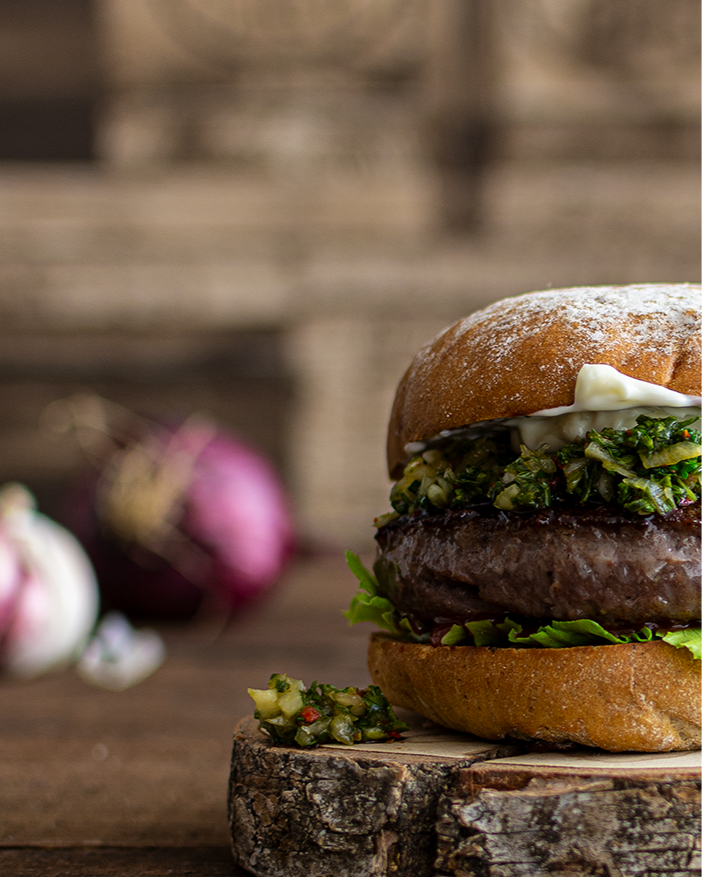 börger-online-kaufen, Burger Zubereitung, Wagyu Burger Patty angebraten mit Zwiebeln, Wagyu Burger Set kaufen, Burger Set mit Wagyu-Patties, Burger Set bestellen, ganzer Burger auf Holzbrett